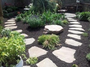 Stone walkway leading through a well-maintained garden